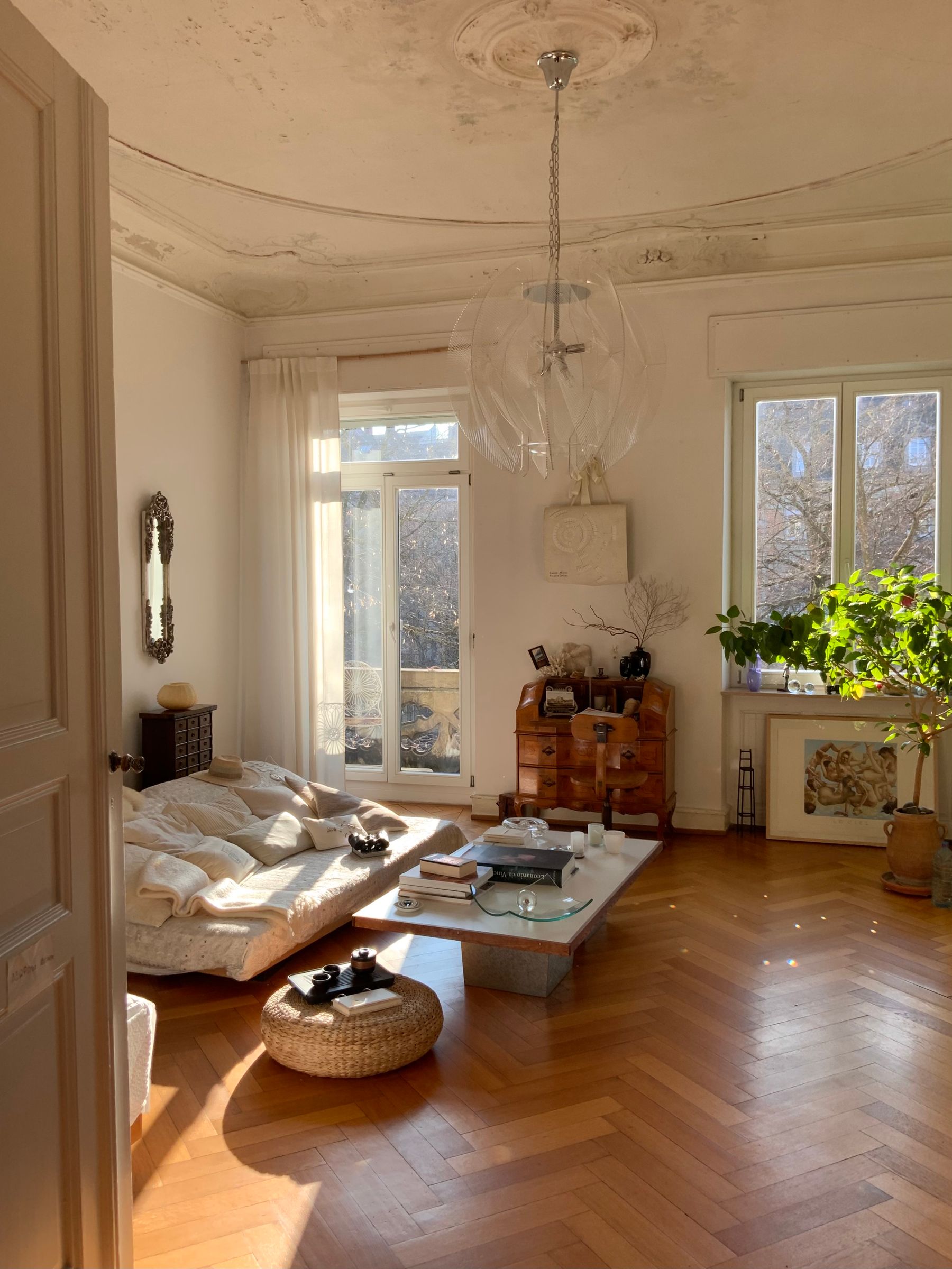 Warm, sunlit living room with a sofa and wooden floor